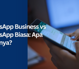 Banner Lenna.AI berjudul 'WhatsApp Business vs WhatsApp Biasa: Apa Bedanya?' dengan ilustrasi smartphone yang sedang digunakan untuk berkirim pesan.